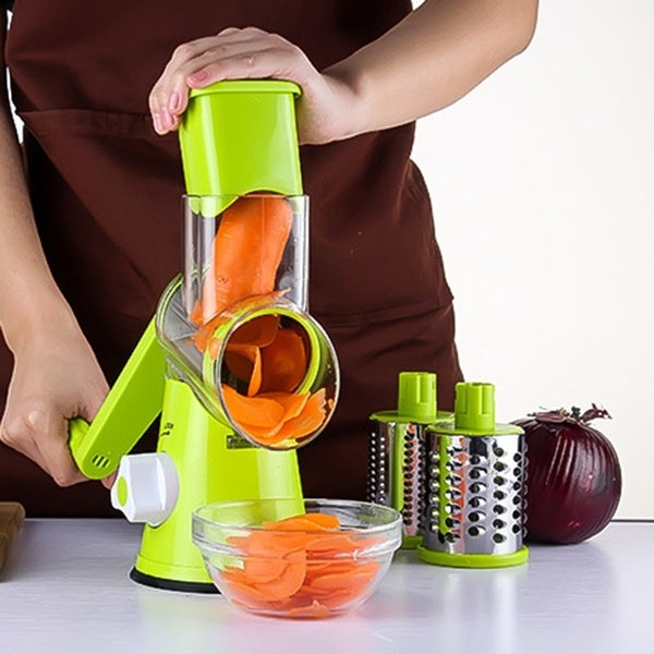 Green electric slicer with clear chute cutting carrot slices into a bowl