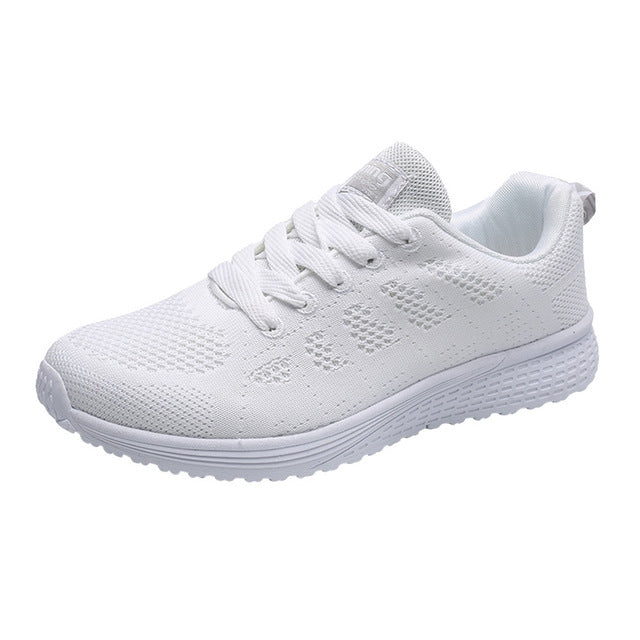 Women’s white mesh running sneakers with white laces, cushioned collar, and thick sole