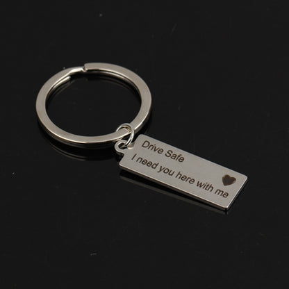 Silver engraved keyring with rectangular tag reading “Drive Safe I need you here with me”