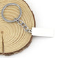 Silver keyring with chain link and white rectangular tag attached, engraved drive safe message