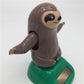 Solar-powered dancing sloth figure on green base, side view with arms raised