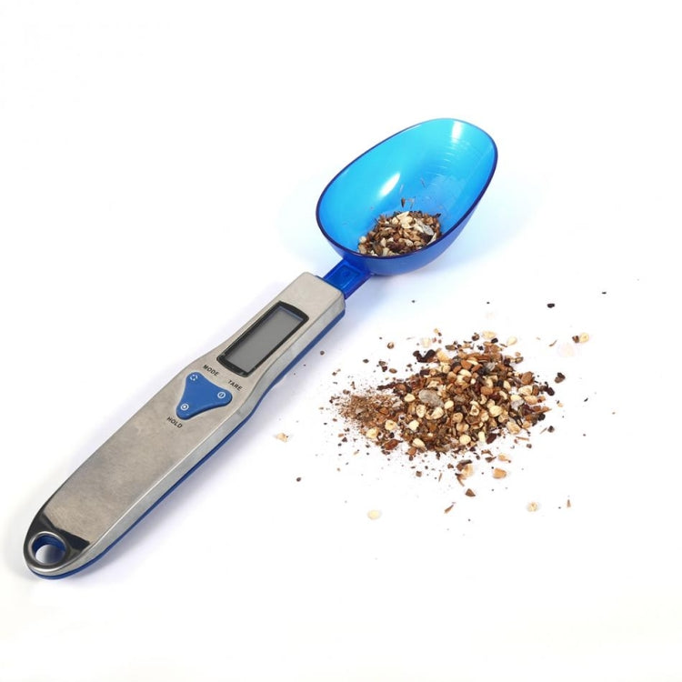 Digital spoon scale weighing nuts in blue scoop with LCD display