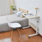 Bedside laptop desk with light wood top, white frame, storage shelf, and rolling casters