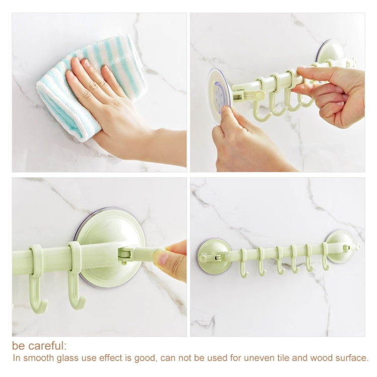 Beige suction hook set being pressed onto smooth tile wall