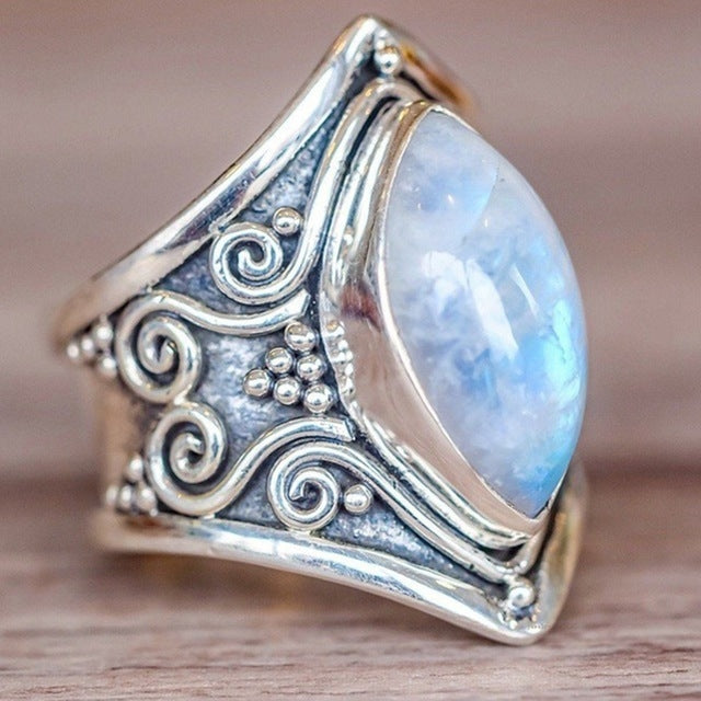 Silver ring with ornate filigree and large oval light-blue gemstone