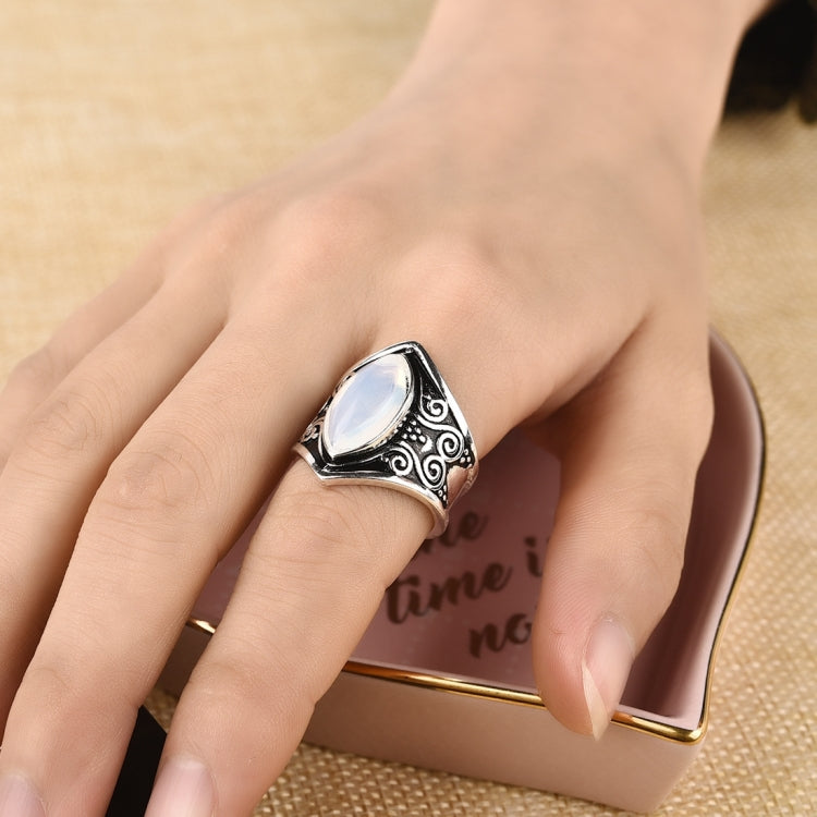 Silver oval gemstone ring with detailed filigree band on hand