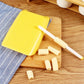 Yellow ridged pasta mold and white roller with formed ridged macaroni on a wooden board