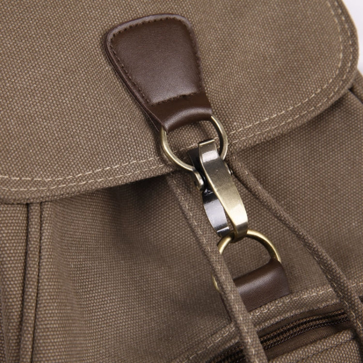 Tan canvas backpack flap with brown leather accent and metal clasp hardware