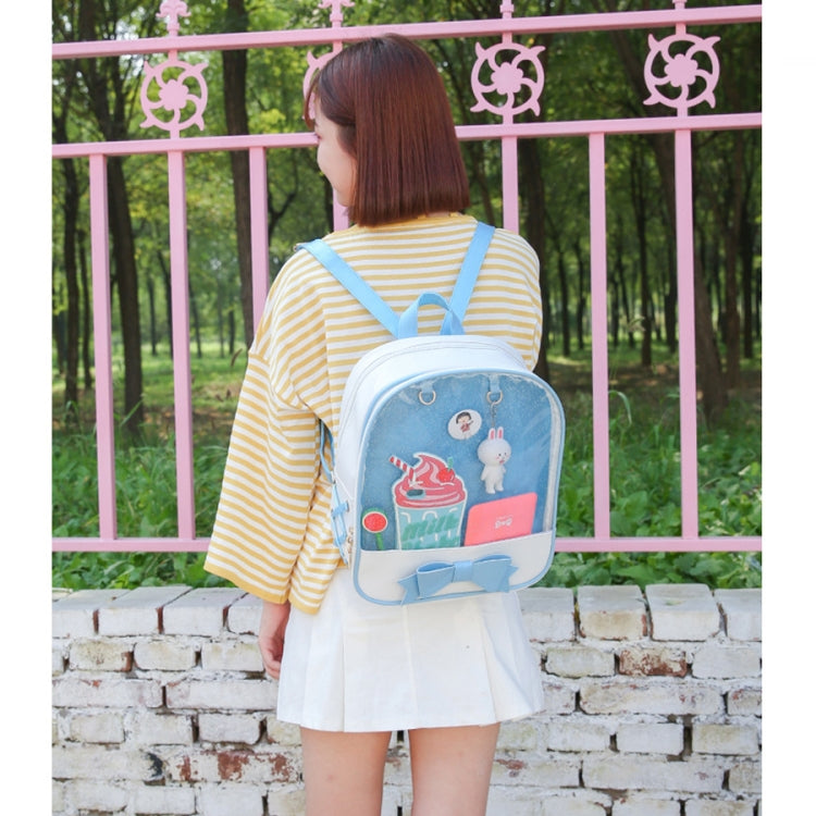 Mini transparent backpack in light blue with cartoon patch and bow accent, worn from behind