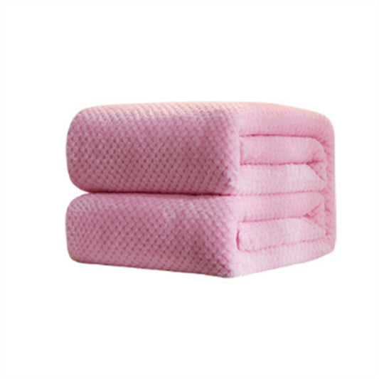 Pink solid color fleece blanket, folded with quilted stitching and textured surface.