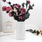 Milk white plastic table vase with fluted sides, filled with faux flowers
