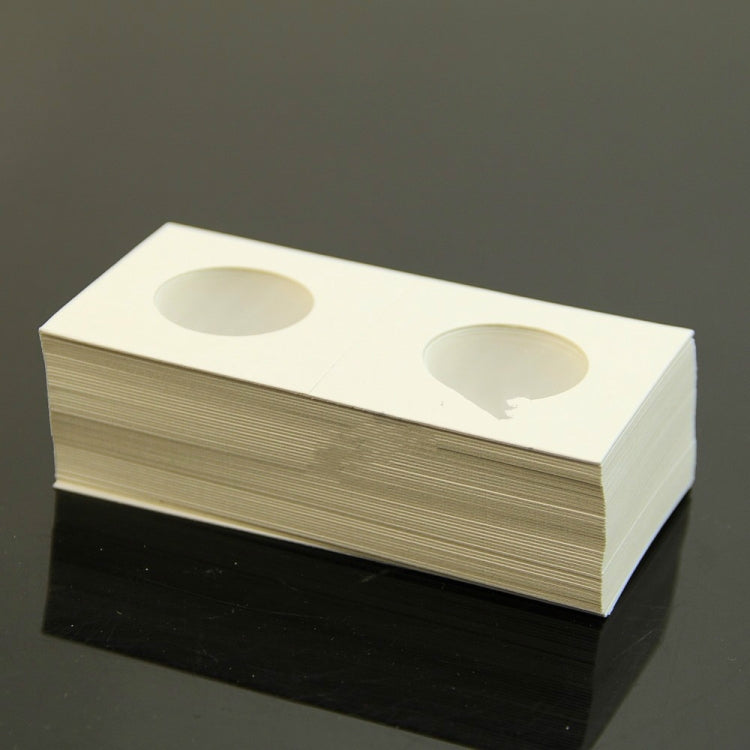 Stack of coin protector paper cards with round cutouts for coin display