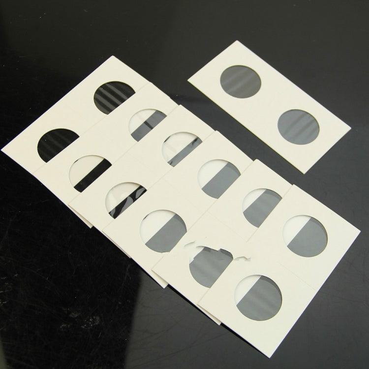 Coin protector card sheets laid out, multiple white squares with round cutouts