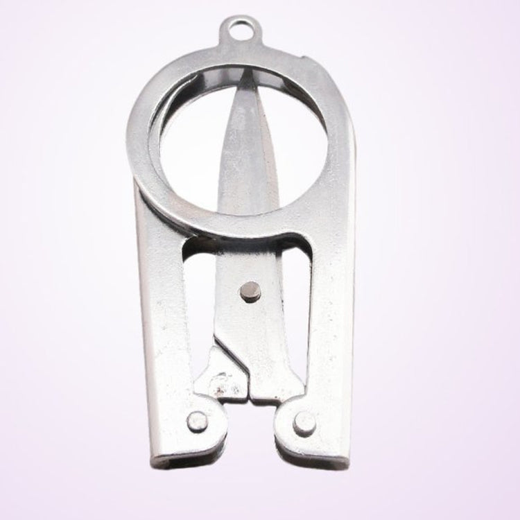 Mini folding scissors close-up of the blade hinge and spring mechanism, silver metal