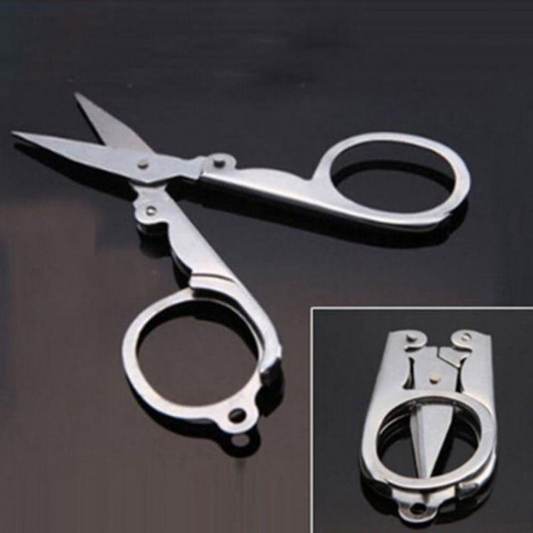 Travel folding scissors with compact hinge, pointed blades, and large finger rings