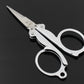 Compact folding scissors with finger rings and pointed blades, silver metal with black accents