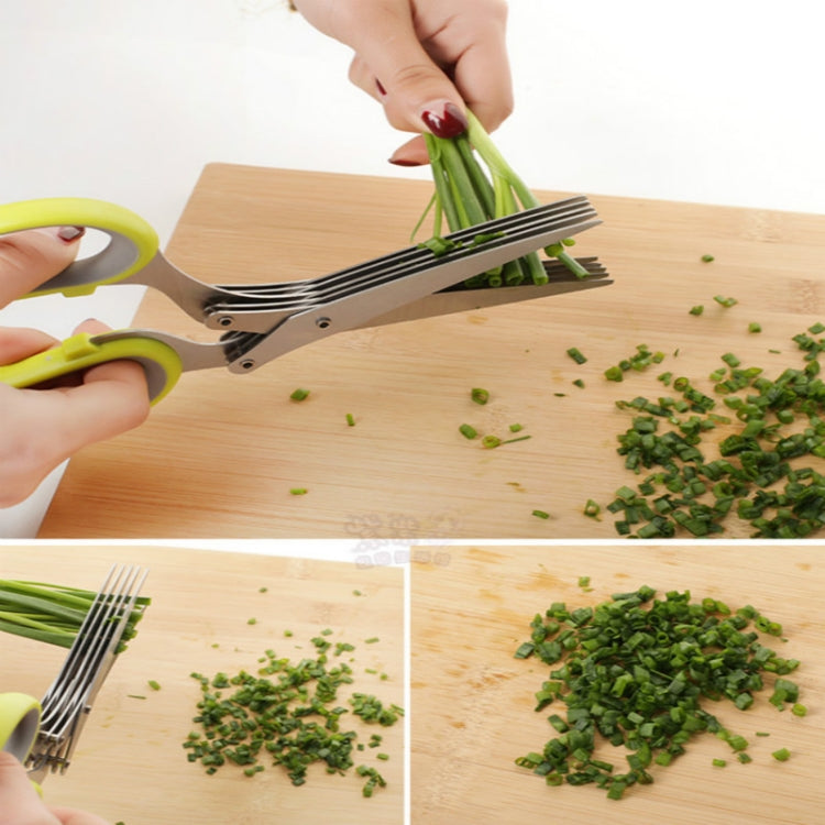 Green herb scissor shredder in hand, chopping scallions on a wooden board
