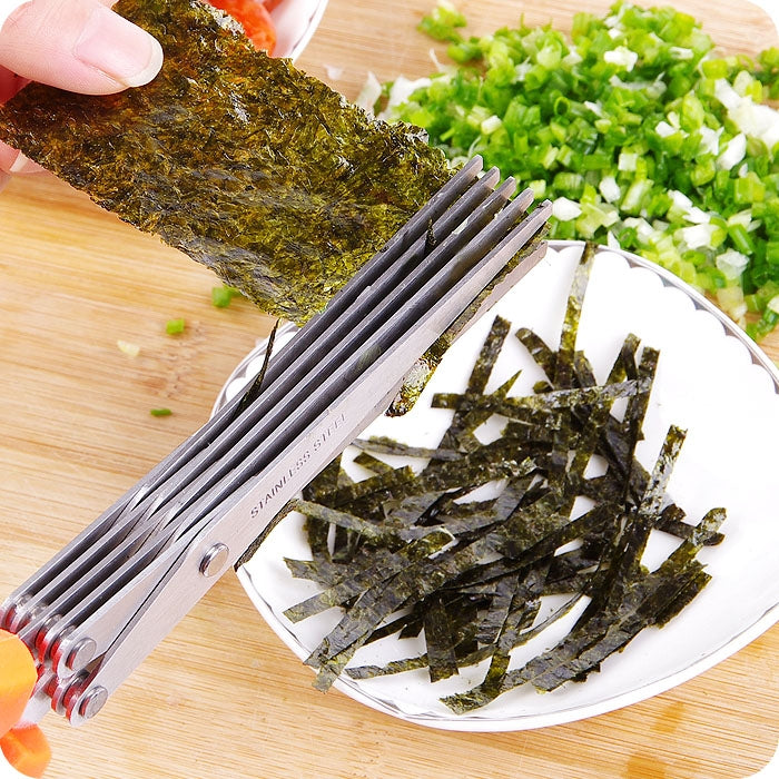 Metal herb scissor shredder slicing leafy ingredients on a cutting board