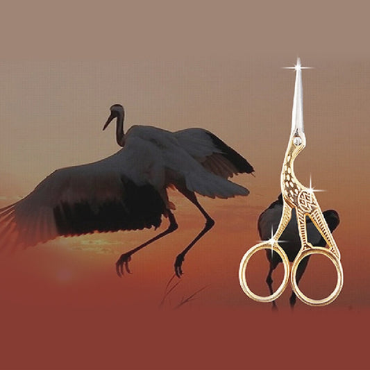 Gold-tone decorative sewing scissors with pointed tips and ornate handle cutouts