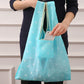 Foldable shopping bag, light teal with white stars, carried tote with wide handles