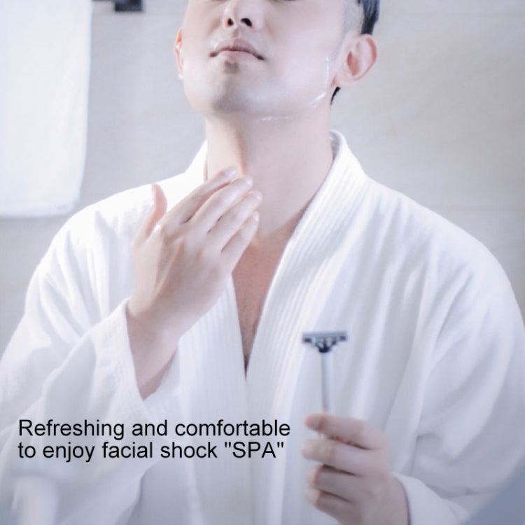 Manual multi-shock razor in hand near face, preparing for shaving