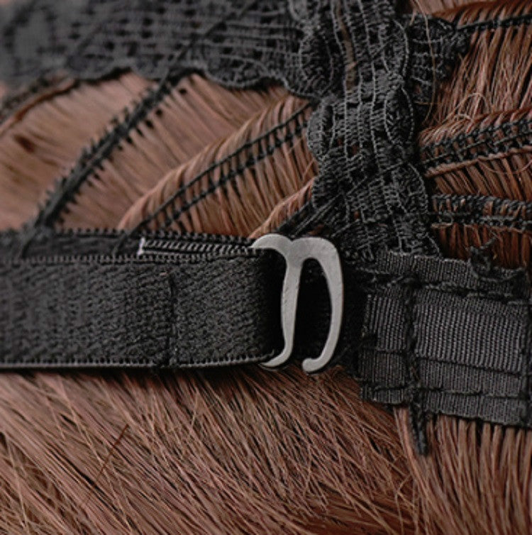 Close-up of wig cap with adjustable strap and metal clasp on dark base