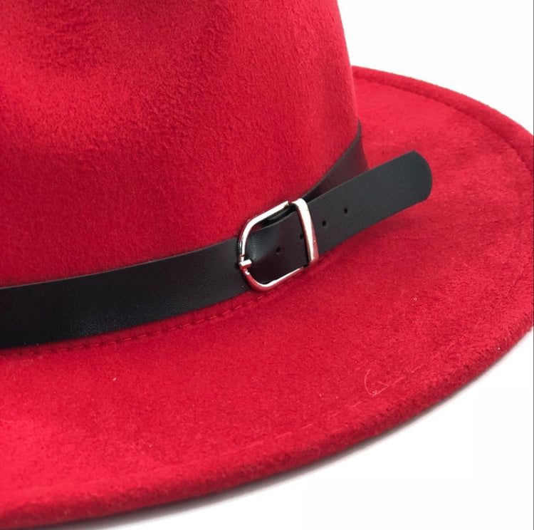 Red fedora hat close-up with black buckle band across the brim, wool-blend style.