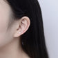 Ear with three small zircon stud earrings lined up, clear stones