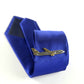 Gold airplane tie clip on blue striped necktie, with matching box behind