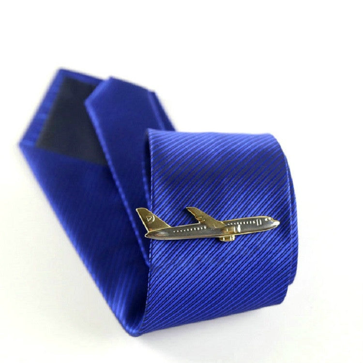 Gold airplane tie clip on blue striped necktie, with matching box behind