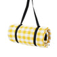 Rolled outdoor camping mat with yellow and white check pattern, secured with black straps