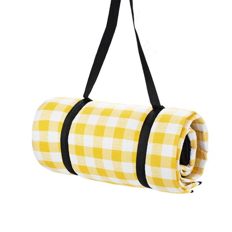 Rolled outdoor camping mat with yellow and white check pattern, secured with black straps