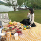Yellow and white checkered beach mat spread on ground for outdoor camping picnic
