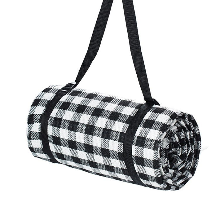 Black and white checkered beach mat roll with black carrying straps