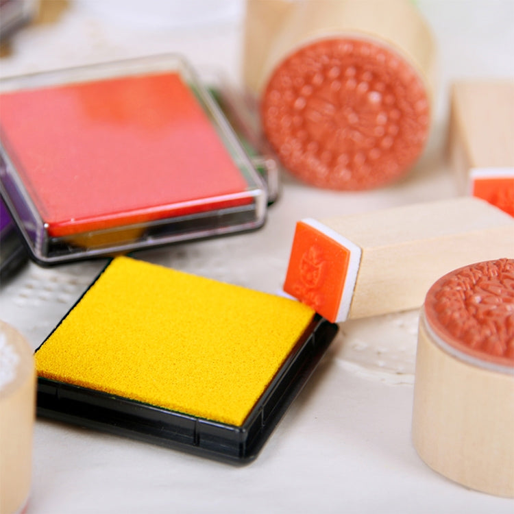 Yellow square ink pad with textured sponge and nearby orange ink pads