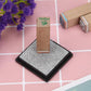 Gray square ink pad on black base, textured sponge ready for stamping