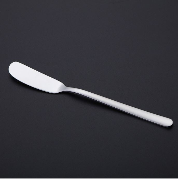 Butter knife with silver finish, long handle and curved, rounded spreader edge.