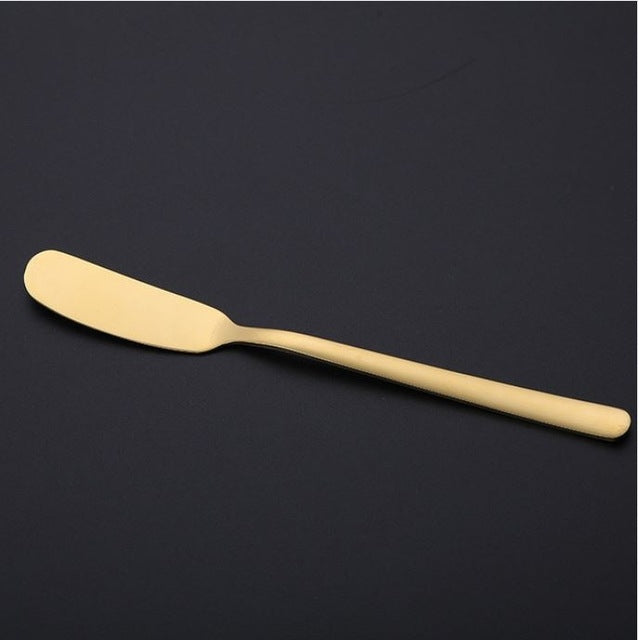 Gold butter knife with a smooth rounded spreader blade and sleek long handle.