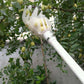 White plastic fruit picking tool with grip cage at end of long handle