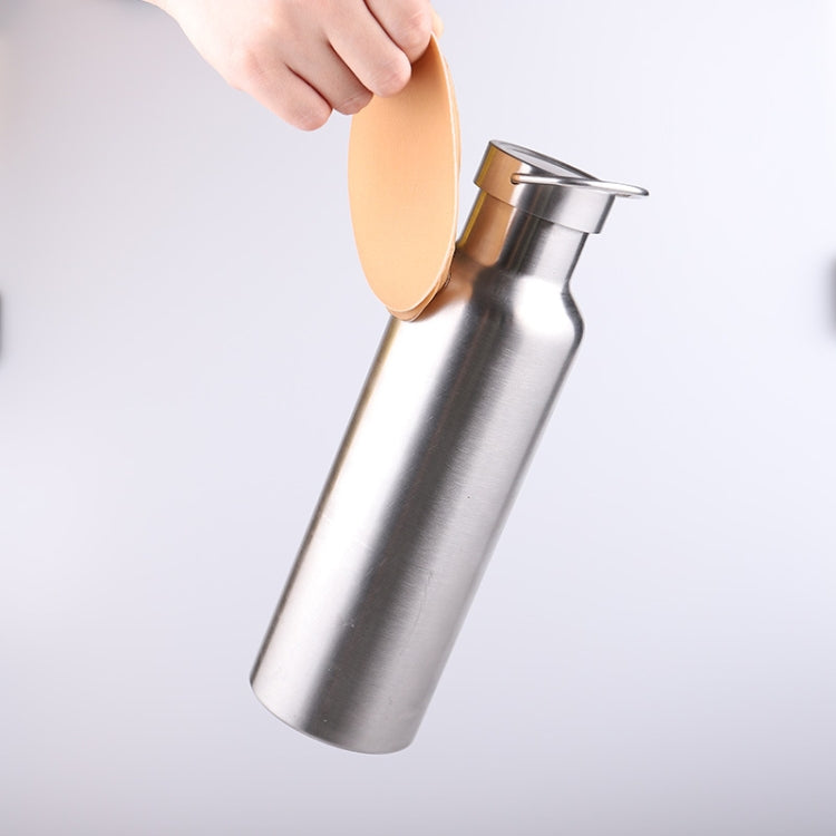 Skin-tone silicone nipple cover pads held above a bottle for flexible storage.