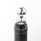 Close-up of round chrome wine bottle stopper with black rubber base and ball top