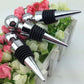 Two chrome wine bottle stoppers with black ribbed rubber and pointed tapered ends