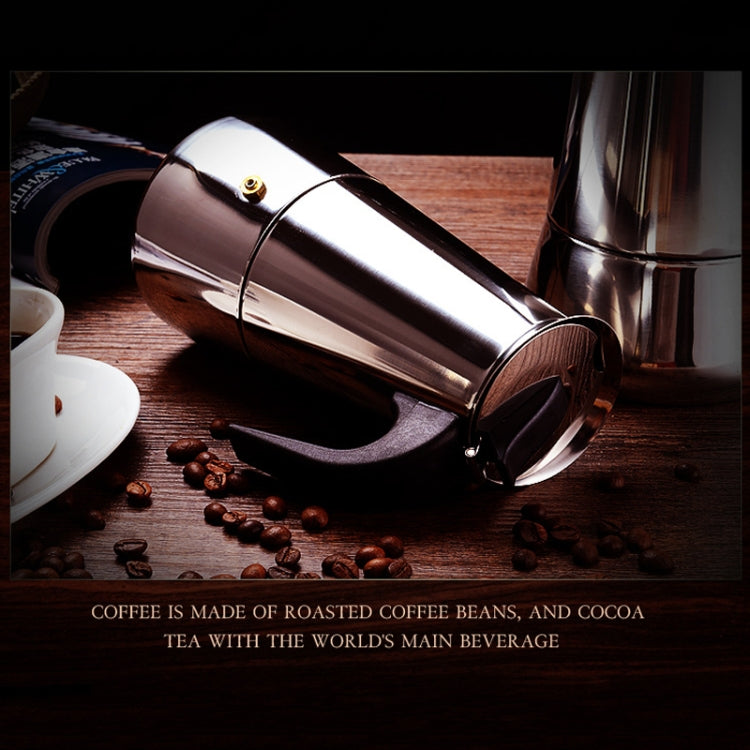 Stainless steel moka coffee maker pot with black handle, close-up