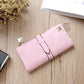 Light pink suede-style long wallet phone bag with zip, wrap flap strap, and gold-tone clasp.