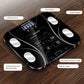 Black digital bathroom weighing scale on wood floor, LCD display and touch buttons