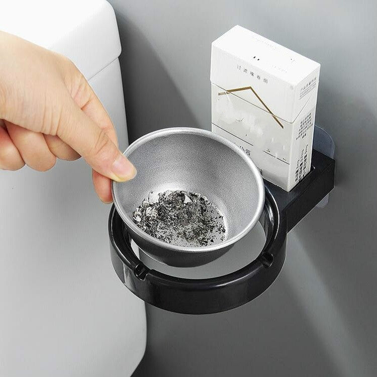 Wall-mounted split ashtray, white open bowl with ashes and cigarette remnants
