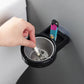 Wall-mounted split ashtray, black with gray insert and cigarette stub in bowl