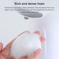 Foam soap dispenser producing thick white lather, hand holding foam under spout
