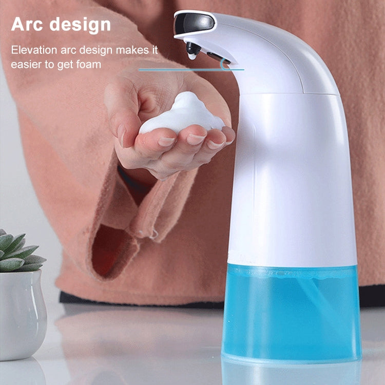 Automatic foam soap dispenser dispensing lather beneath an arched spout
