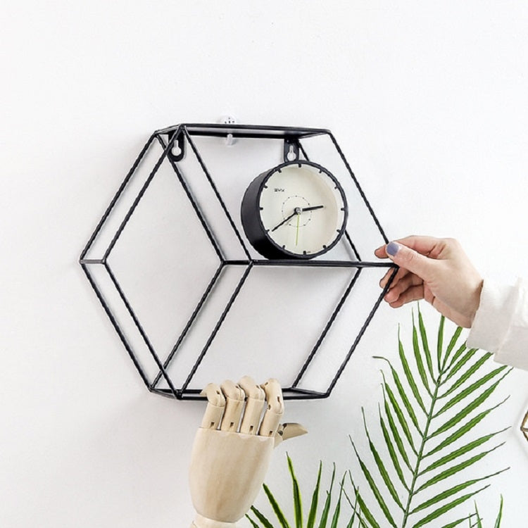 Black hexagonal hanging wall shelf holding a round clock on the shelf